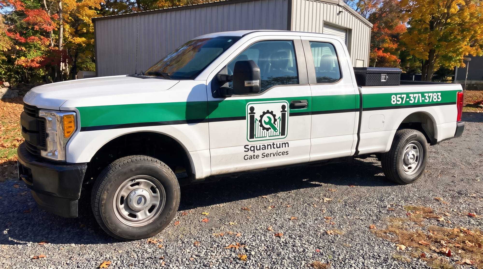 White Squantum Gate Services pickup with a green stripe, the company logo on the front door and the phone number on the bed